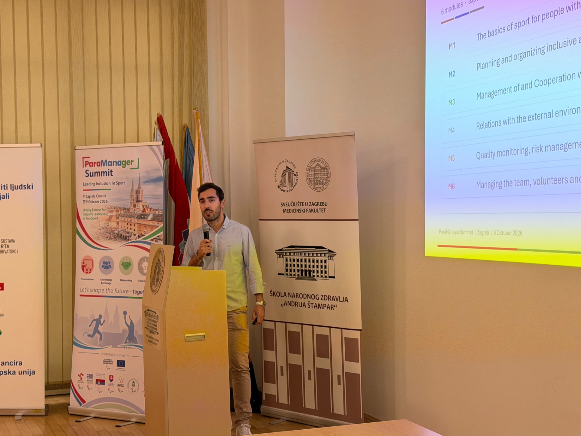 Orador ao microfone na conferência final do projeto ParaManager, em Zagreb, com o ecrã a mostrar os seis módulos do programa de formação.